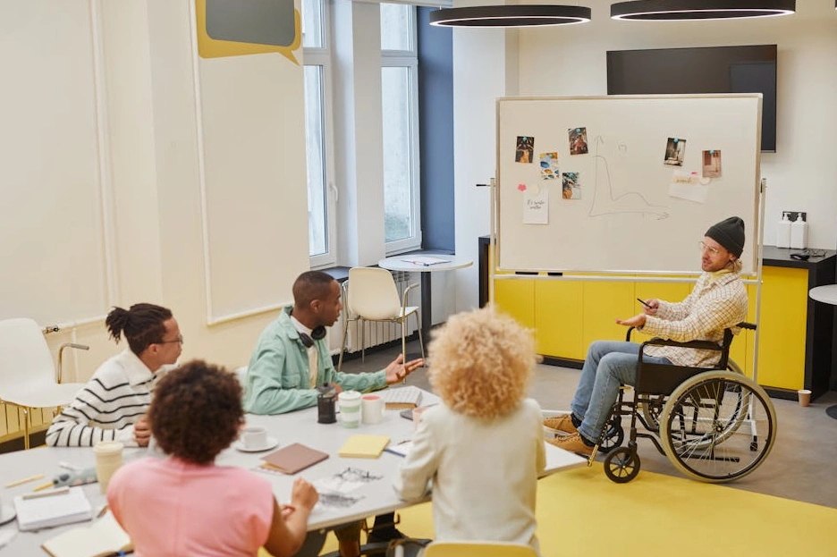 Team diversificato di professionisti del marketing che discute strategie davanti a una lavagna.